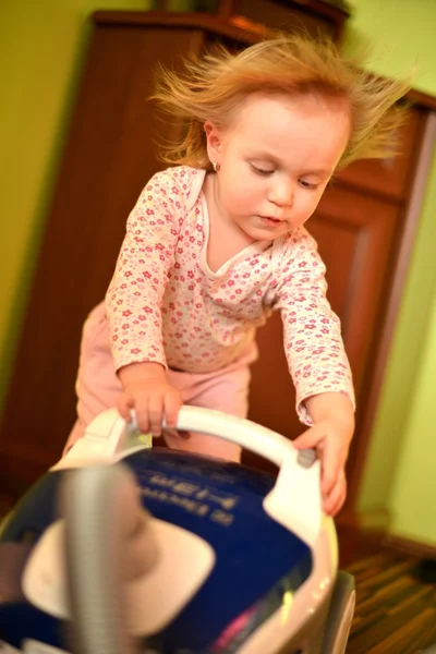 Baby with vacuum cleaner in living room — Stock Photo, Image