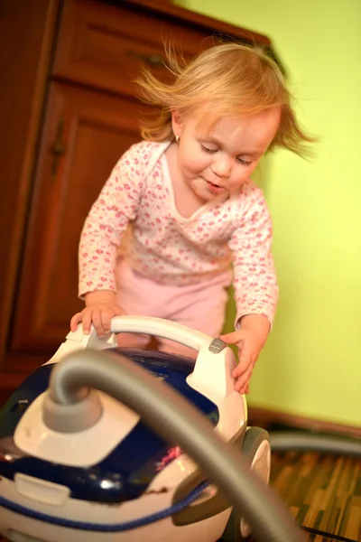 Bebê com aspirador de pó na sala de estar — Fotografia de Stock