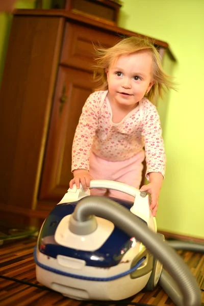 Baby with vacuum cleaner in living room — Stock Photo, Image