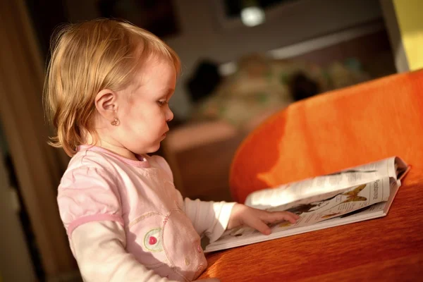 Little girl reading a magazine — Stock Photo, Image