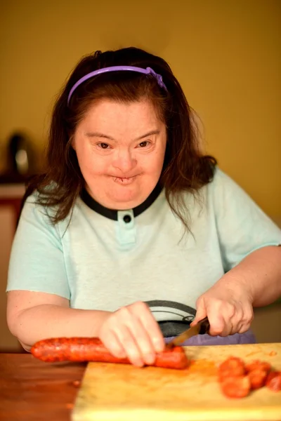 Aantrekkelijke down syndroom vrouw aanspanning in de keuken — Stockfoto