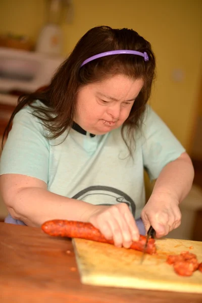 Aantrekkelijke down syndroom vrouw aanspanning in de keuken — Stockfoto