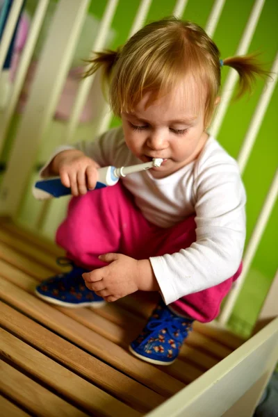 Retrato de uma linda menina isolada no verde com escova de dentes — Fotografia de Stock