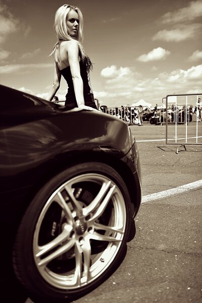 Сексуальная девушка позирует у машины
