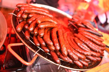 Sausages on grill closed-up. clipart