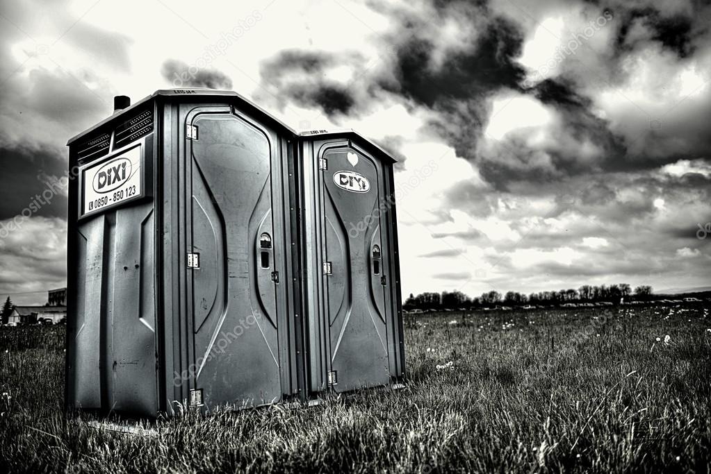 Two portable bathrooms on a cloudy overcast day