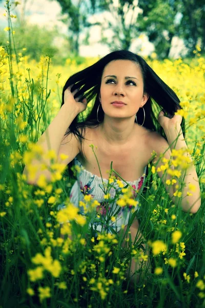 Meisje in een veld van gele bloemen — Stockfoto