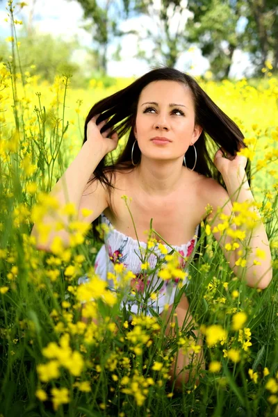 Flicka i ett fält av gula blommor — Stockfoto