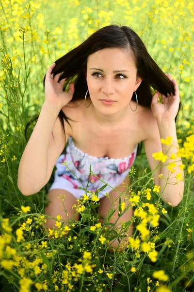 Lány a mező sárga virágok — Stock Fotó