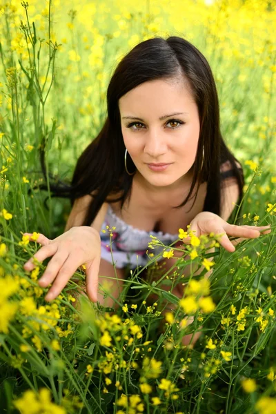 Menina em um campo de flores amarelas — Fotografia de Stock