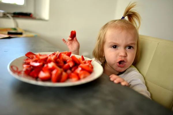 Küçük kız çilek yiyor. — Stok fotoğraf