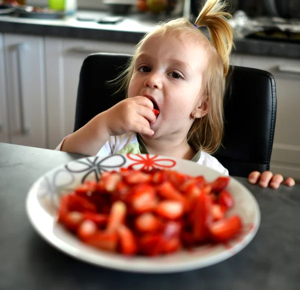 Küçük kız çilek yiyor. — Stok fotoğraf