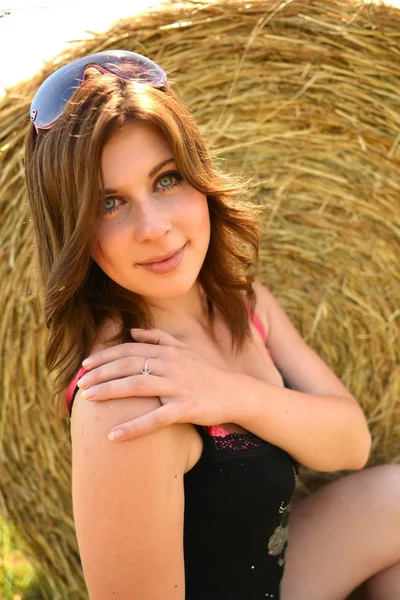 Pretty girl resting on straw bale — Stock Photo, Image