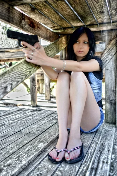 Jovem mulher bonita segurando uma arma — Fotografia de Stock