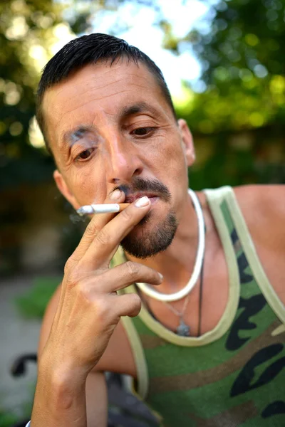 Człowiek siedzi i palenie papierosów — Zdjęcie stockowe