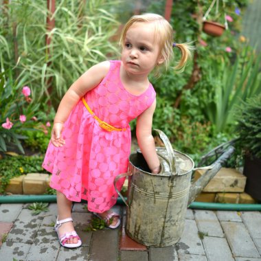 sevimli kıvırcık kız bahçede çiçek sulama