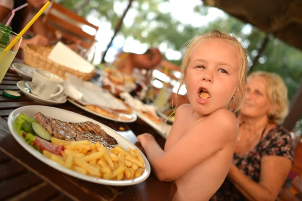 Güzel patates kızartması yiyen küçük kız gülerek — Stok fotoğraf