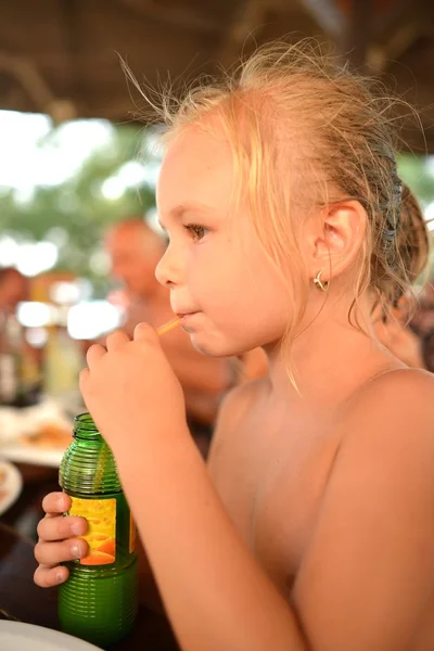 Klein meisje drinken sinaasappelsap — Stockfoto