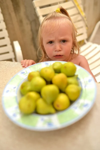 Girl and figs on the plate — Stock Photo, Image
