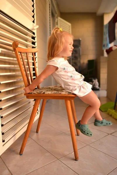 Baby girl sitting on chair — Stock Photo, Image