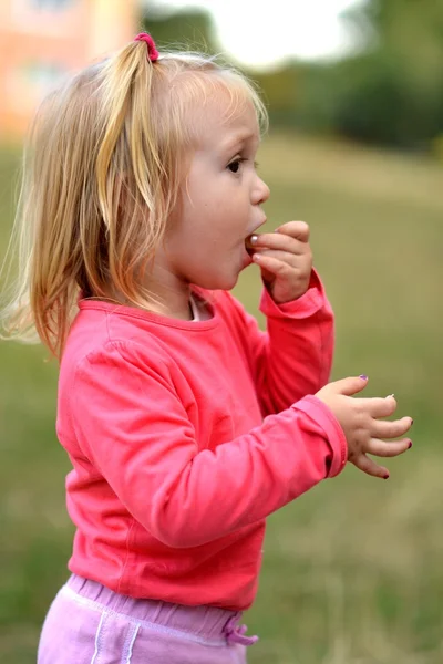 小さな女の子食べるトウモロコシ ニブルします。 — ストック写真