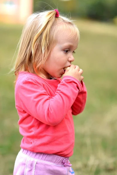 Little girl eating corn nibbles — Stock Photo, Image