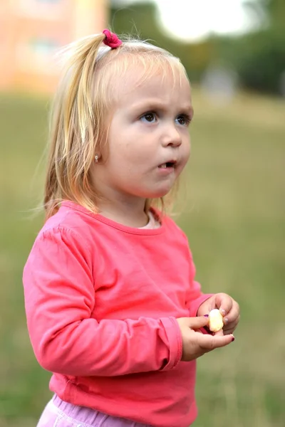 Kis lány étkezési kukorica nibbles — Stock Fotó