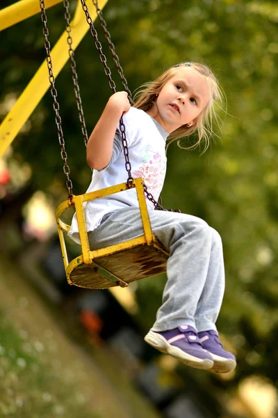 Menina jogando no balanço — Fotografia de Stock