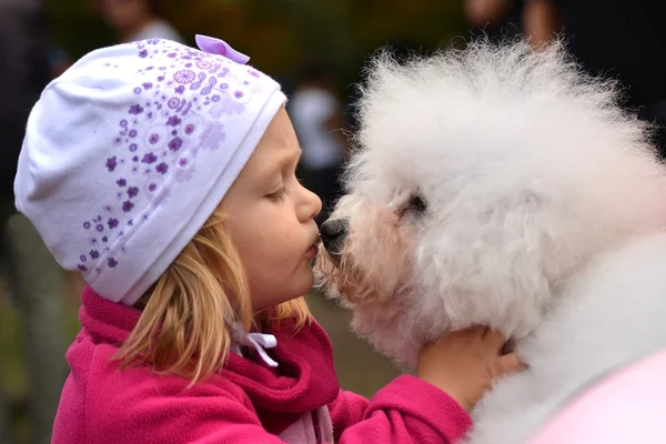 Children girl kissing her puppy — Stock Photo, Image