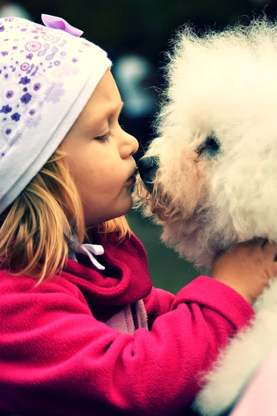 Children girl kissing her puppy — Stock Photo, Image