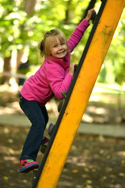 Menina jogar em um parque infantil — Fotografia de Stock