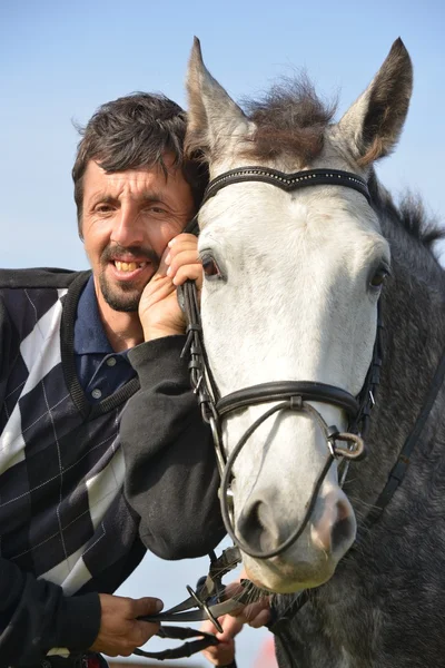 Bonito homem sorridente com cavalo — Fotografia de Stock