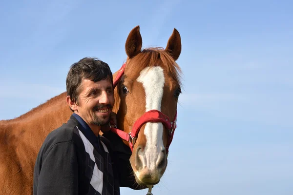 Schöner lächelnder Mann mit Pferd — Stockfoto