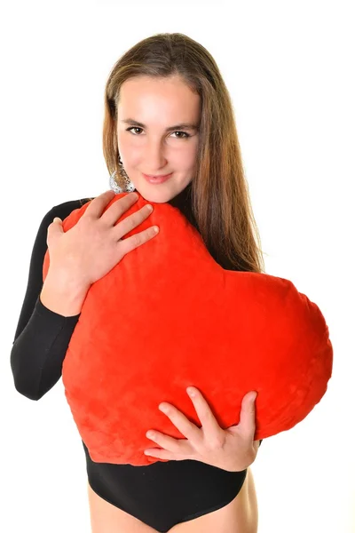 Молодая женщина с красной подушкой в форме сердца — стоковое фото