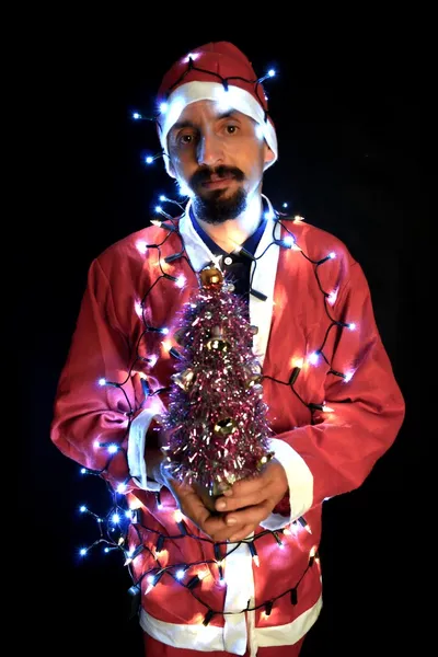 Tema natalizio con Babbo Natale che tiene in mano luci magiche — Foto Stock