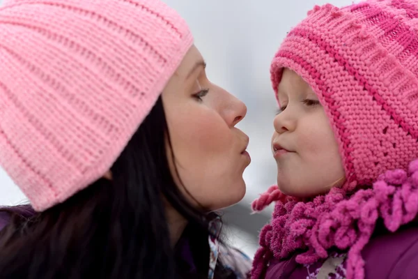Moeder en haar dochtertje genieten van prachtige winter dag in de buitenlucht — Stockfoto