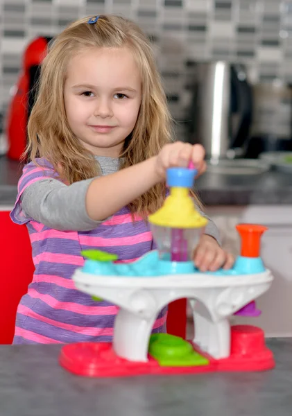 Girl playing toy kitchen — Stock Photo, Image