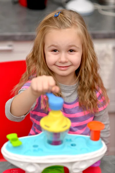 Girl playing toy kitchen — Stock Photo, Image