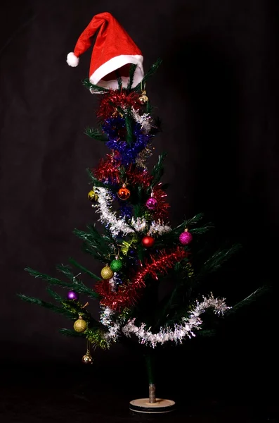 Christmas background decorated tree with santa hat on it — Φωτογραφία Αρχείου