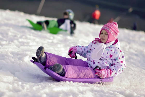 Portret van gelukkig meisje in winter fun, sneeuw, familie rodelen — Stockfoto