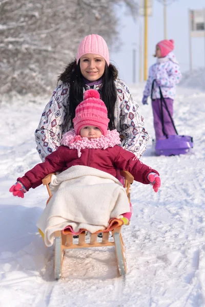 Madre e hija trineo, escena de invierno agradable —  Fotos de Stock