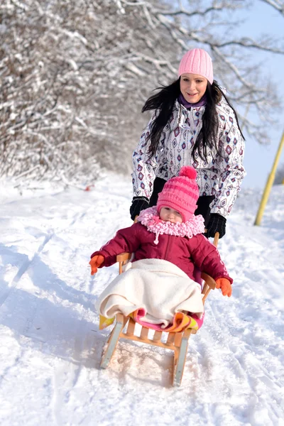 Moeder en dochter sleeën, mooie winters tafereel — Stockfoto