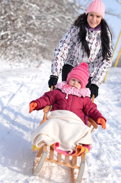Anne ve kızı güzel kış sahne sledging, — Stok fotoğraf