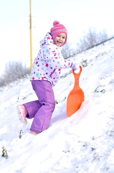 Portret szczęśliwy dziewczyna w sankach zimą — Zdjęcie stockowe