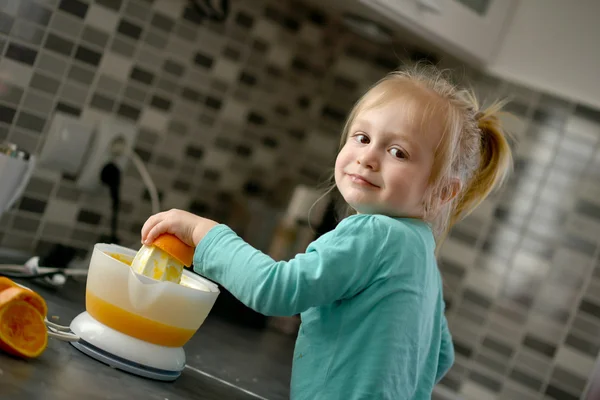 Ребенок делает свежий апельсиновый сок — стоковое фото