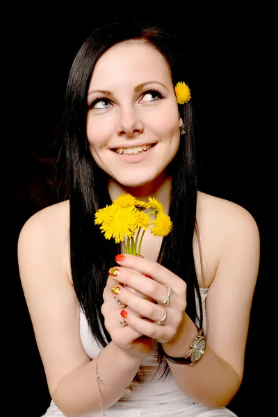 Vrouw bedrijf paardebloemen — Stockfoto