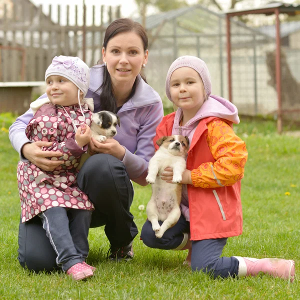 Two sisters and mother with puppies — Stock Photo, Image