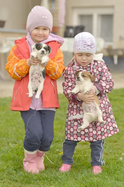 Sœurs jouant avec des chiots — Photo