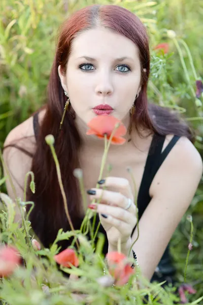 Mulher segurando uma flor de papoula — Fotografia de Stock