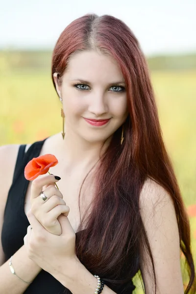 Vrouw met een klaproos bloem — Stockfoto